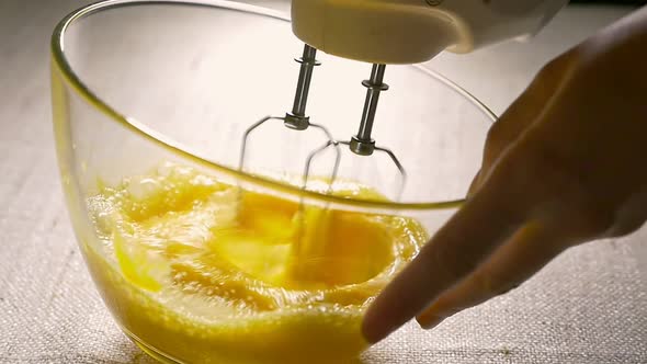 Electric Mixer Beaters Eggs in Glass Bowl. Cooking, Close-up. Slow Motion