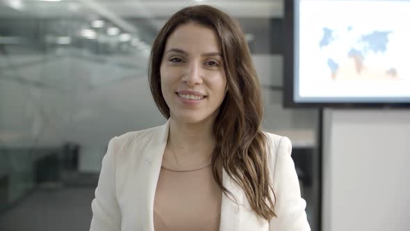 Beautiful Young Businesswoman Looking at Camera and Nodding