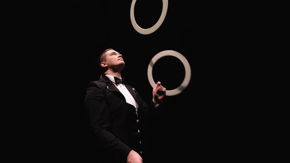 Camera Rotates Around Showman Trowel Juggling White Rings