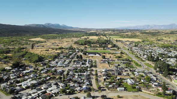 Aerial flying over Trevelin town houses on a valley in the middle of Andean mountains, Patagonia Arg