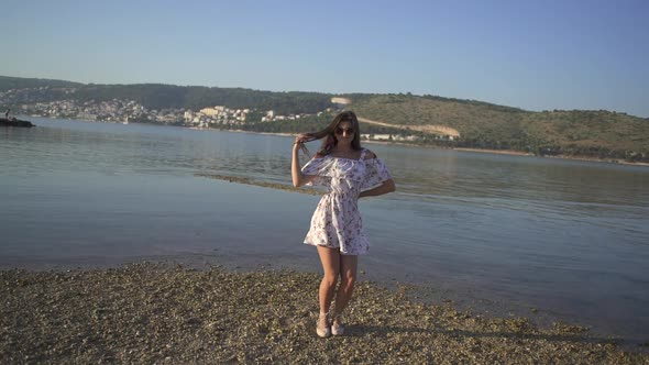 Beautiful Girl in a Light Dress Dances By the Sea. Strong Camera Movement.