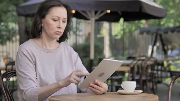 Online Shopping Failure on Tablet for Old Woman Sitting Outdoor