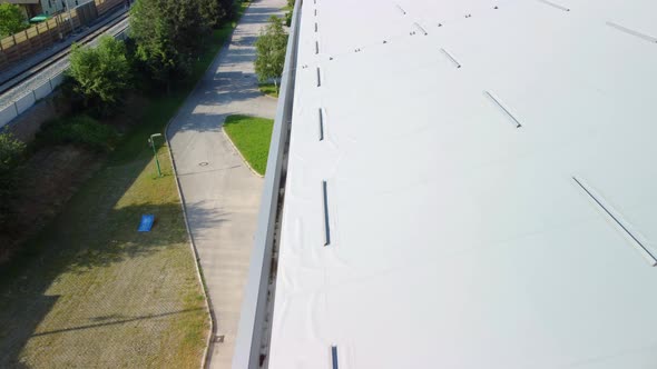 Flying over thermal insulation roof panels with metal sheet gutter at side. Aerial 4k view.