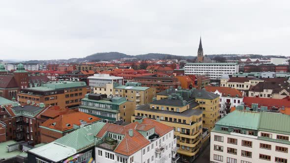 Colorful living apartment buildings and church tower of Borås town, aerial fly forward view