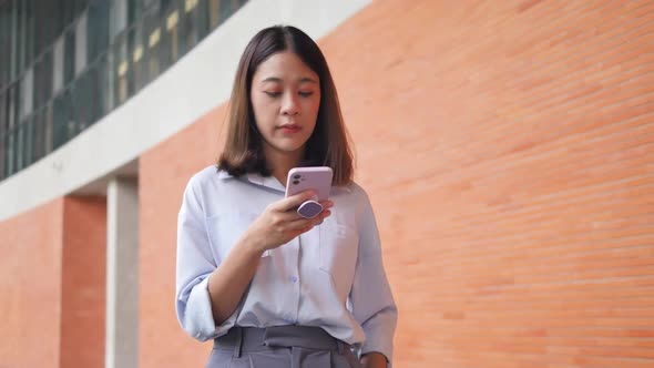 Young asian woman using smartphone on street