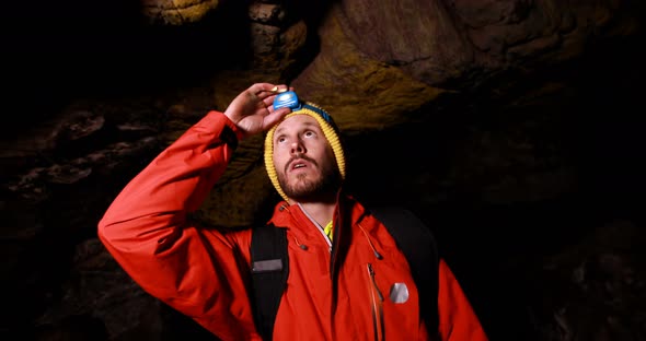 Male hiker exploring a dark cave 4k