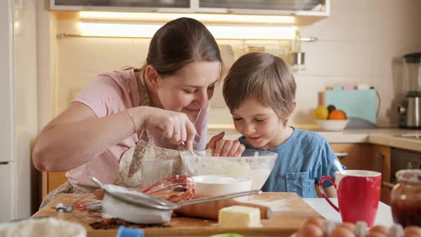 Happy Smiling Boy Kissing His Mother While Making Biscuit Dough at Home