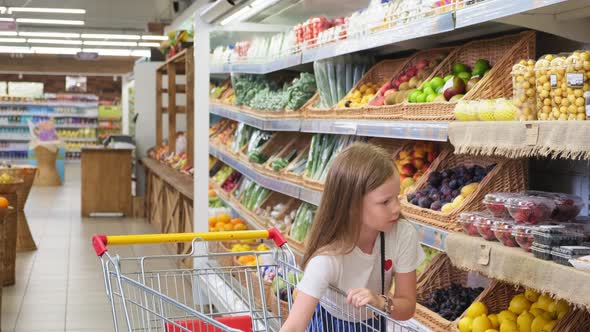 Girl Chooses Products in the Hypermarket