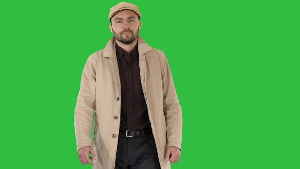 Fashionable man with dark beard in trench coat walking