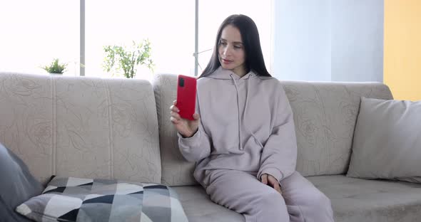 Nervous Woman Looks at Smartphone Screen