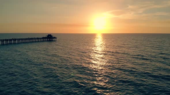 Fly Back Aerial Shot of Silhouette of Fishing Pier