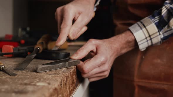 Carpenter Sharpening a Chisel