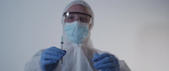 Nurse lifting a syringe and opens cap slow motion