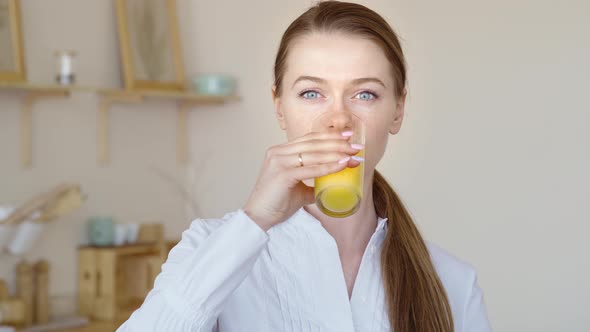 Beautiful Girl Drinking Fresh Orange Juice From Glass. Close Up Happy Woman Drinking Fruit Beverage