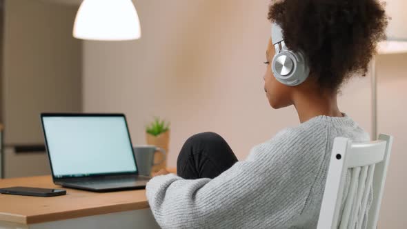 Shopping Online African Teen Girl Sits at a Desk and Uses a Laptop Surfing the Internet a Female