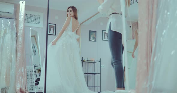 Beautiful and Happy Girl Trying on a Luxurious Wedding Dress