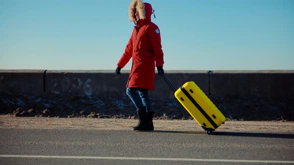 Woman Walking With Yellow Travel Bag. Traveler Transportation With Suitcase. Woman Walking On Road.