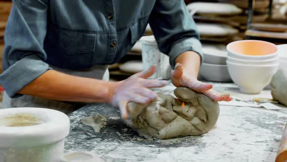 Mid section of female potter molding a clay 4k