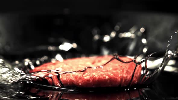 The Super Slow Motion Raw Burger Falls on the Pan with a Splash of Oil
