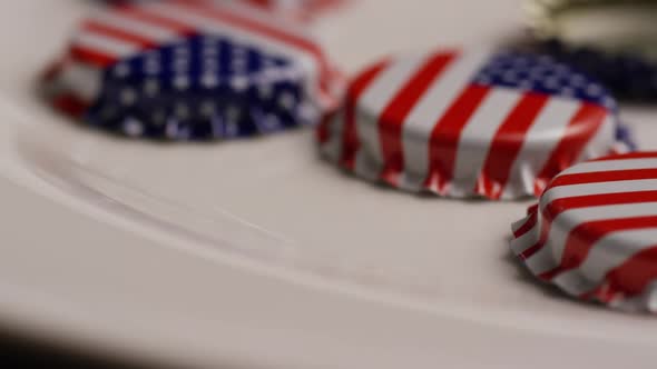 Rotating shot of bottle caps with the American flag printed on them