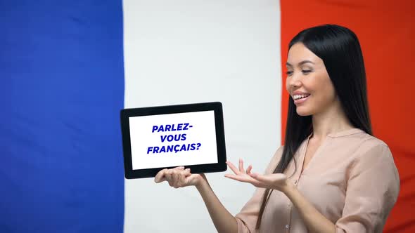 Woman Holding Tablet With Do You Speak French Phrase, App for Learning Language