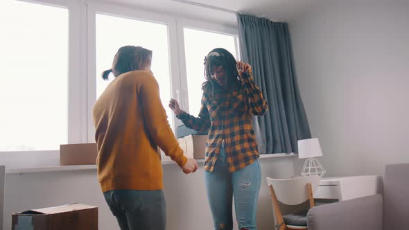 Happy Young Couple Dancing in Front of the Window of Their New Appartment