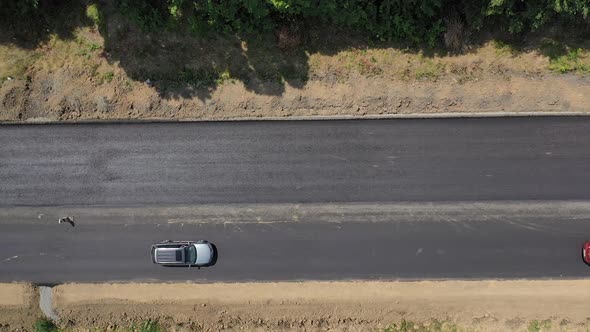 Top view of cars moving on new asphalt road. View from above on finished part of the road. 