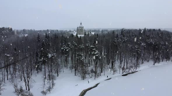 Snow covered Pazaislis monastery during heavy snowstorm day, drone ascend view