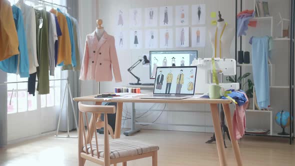 A Laptop Is On The Table Showing Clothes Pictures In The Designer Studio