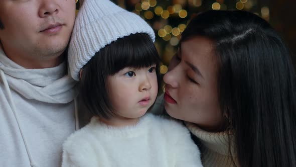 Korean Family with Daughter Sitting in White Sweaters Christmas Tree