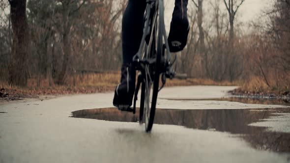 Cyclist Twists Pedals And Riding On Road Bicycle. Cyclist Pedaling On City Park At Autumn. Workout.