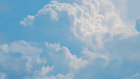 Time lapse of beautiful white fasting puffy cumulus clouds in sunny summer day, medium shot