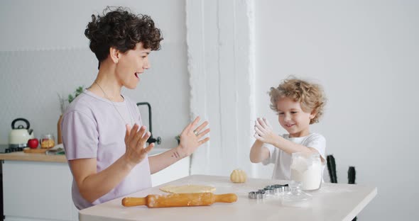 Happy Child Having Fun with Flour Clapping Hands Cooking Pastry with Mom at Home