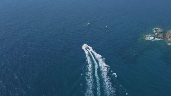 Beautiful motorboat sailing in a wonderful blue sea, small boats near the coast in Costa Brava, Spai