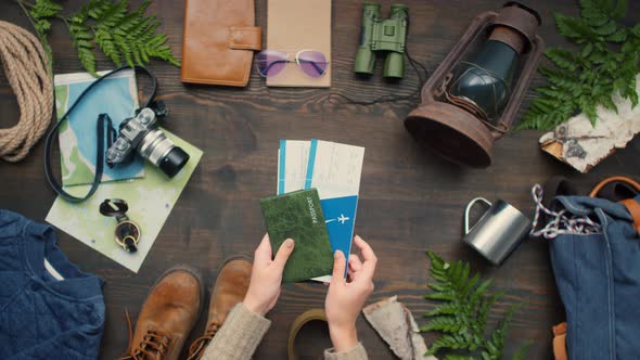 Female Hands Putting Passports and Airline Tickets on Table