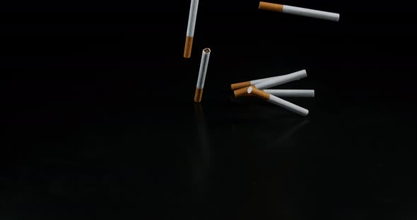 Cigarettes Falling against Black Background, Slow Motion 4K