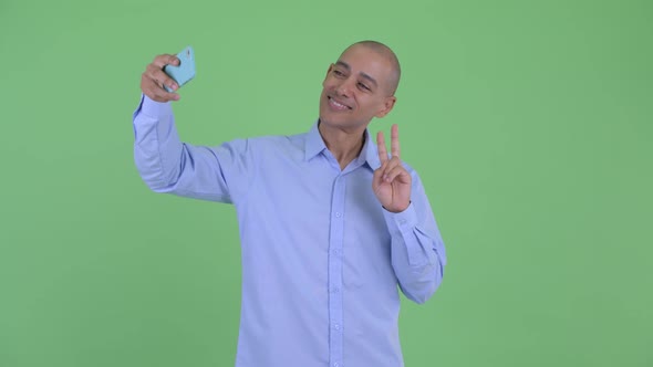 Happy Bald Multi Ethnic Businessman Taking Selfie and Video Calling