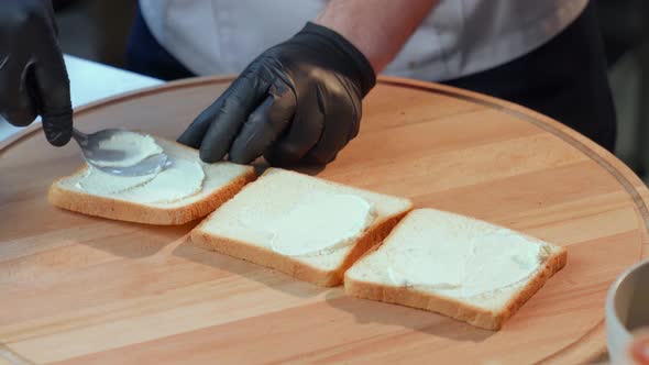 Close Up of Man in Gloves Applying Spread on Bread