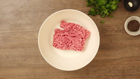 Crop cook putting minced meat in bowl plate