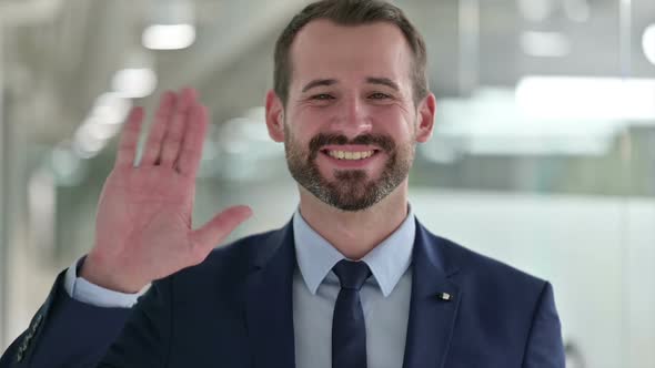 Portrait of Cheerful Businessman Waving at the Camera