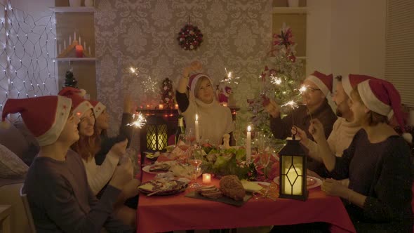 Cheerful Big Family on Christmas Reunion Celebrating with Sparklers in Hands