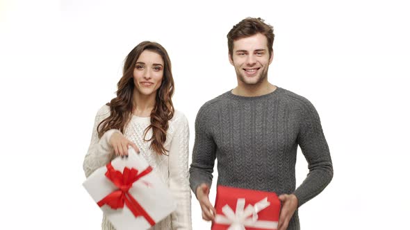  Young Couple Showing and Giving Present To Camera on White Isolated Background.