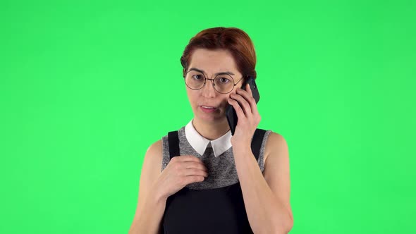 Portrait of Funny Girl in Round Glasses Is Talking for Mobile Phone. Green Screen