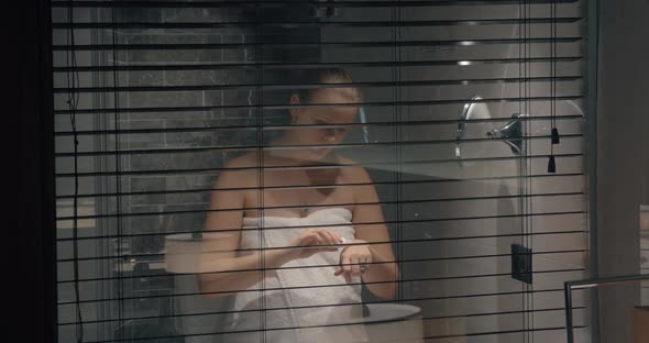 Woman in Bathroom Applying Hand Lotion