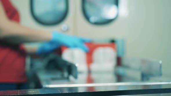 Factory Worker Placing Red Paper Tissues Onto a Moving Conveyor