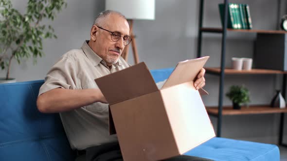 Happy 70s Grandfather Unpacking Cardboard Box Marketplace Online Shopping Delivery Positive Emotion