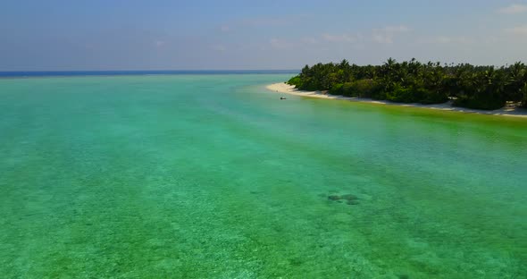 Beautiful fly over travel shot of a white paradise beach and blue sea background in colourful 4K