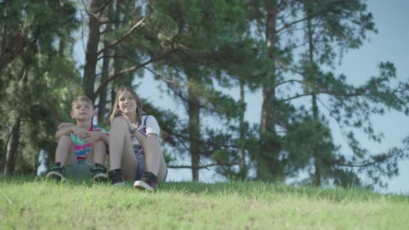 Children sitting together on hillside looking at view