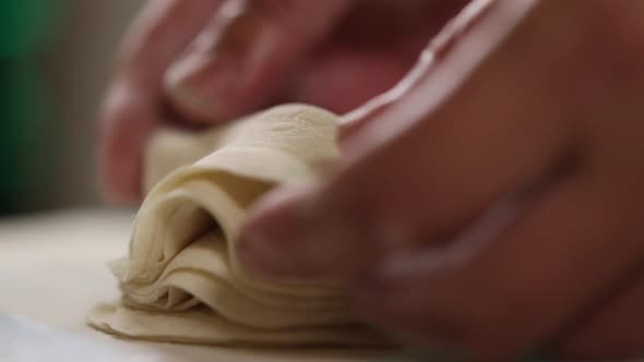 Professional chef neatly stacks prepared dumpling dough. Extreme close up shot.