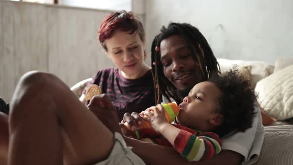 Multiracial Curly Boy Drinking From Feeding Bottle alt